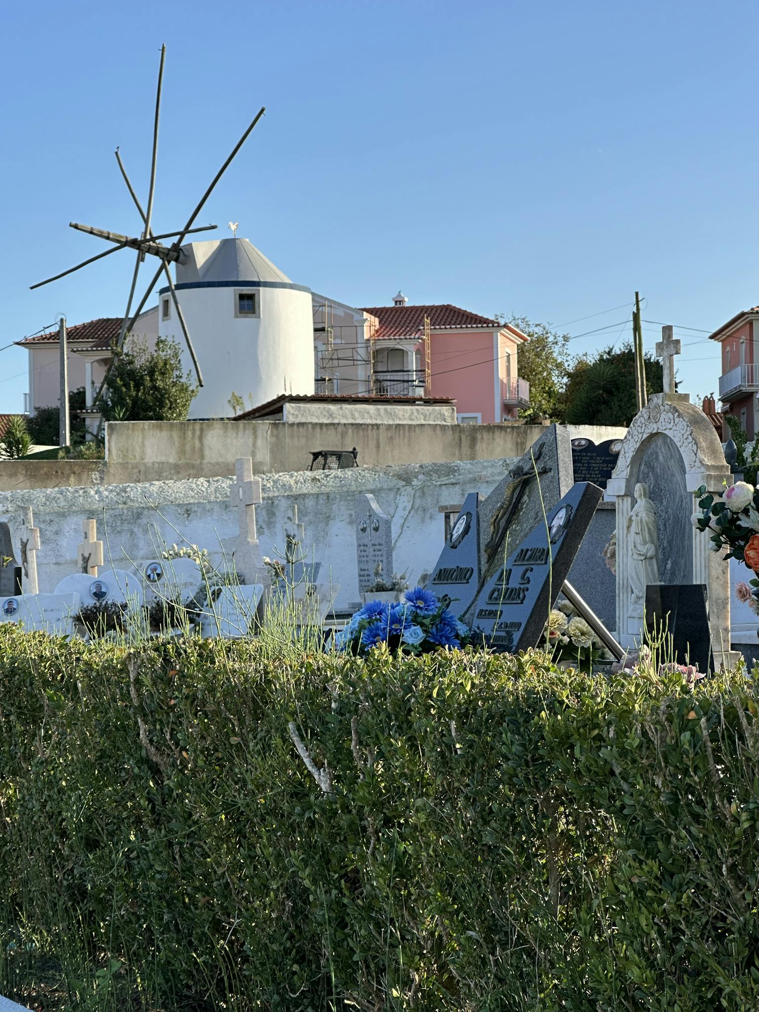 Charming cemetery view with historic windmill in Lourinhã, Portugal.